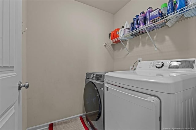 laundry area featuring laundry area, washer and clothes dryer, and baseboards