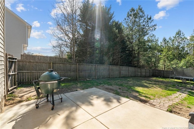 view of patio / terrace featuring a fenced backyard, a trampoline, and grilling area