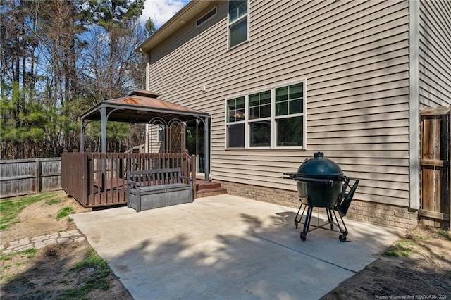 view of patio with grilling area, fence, a deck, and a gazebo