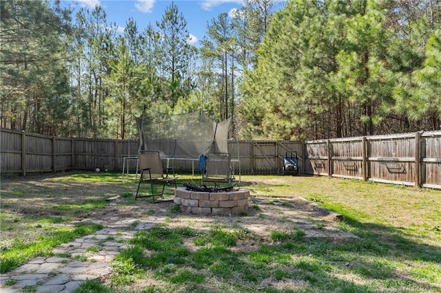 view of yard with a trampoline and a fenced backyard