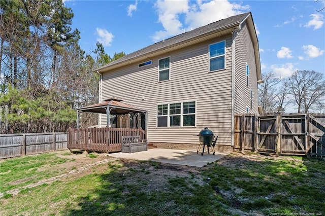 rear view of property with a yard, a gazebo, a patio area, a fenced backyard, and a wooden deck