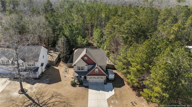 birds eye view of property featuring a forest view