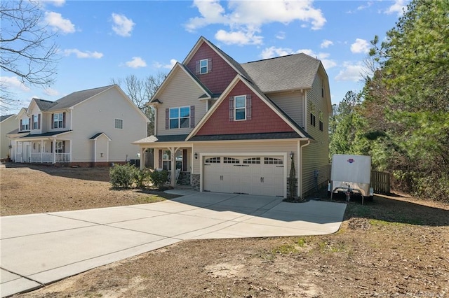 craftsman-style house with a garage, driveway, and stone siding