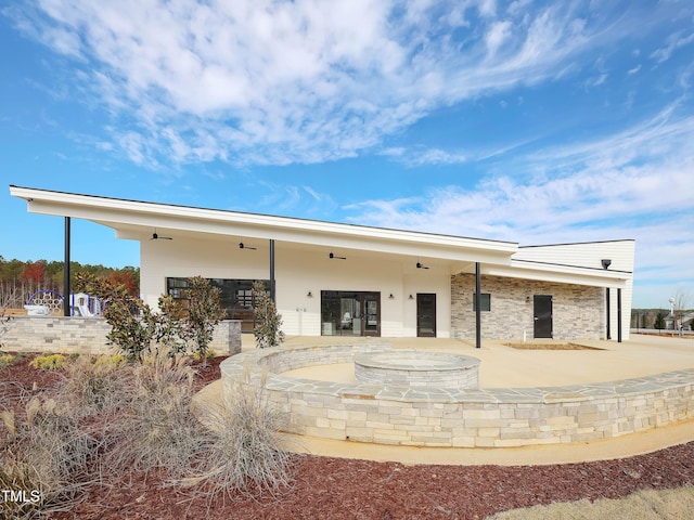 rear view of property featuring ceiling fan and a patio