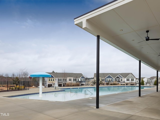 community pool with a residential view, fence, and a patio