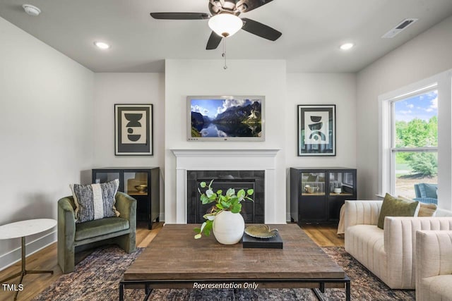 living area featuring visible vents, a tiled fireplace, ceiling fan, wood finished floors, and recessed lighting