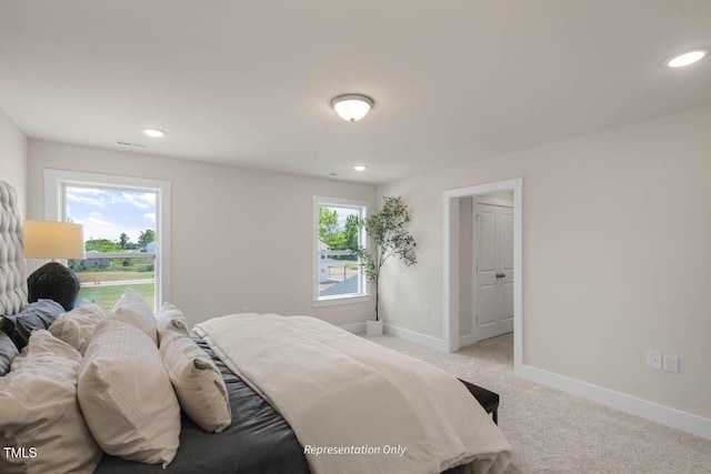 bedroom with recessed lighting, multiple windows, baseboards, and light colored carpet