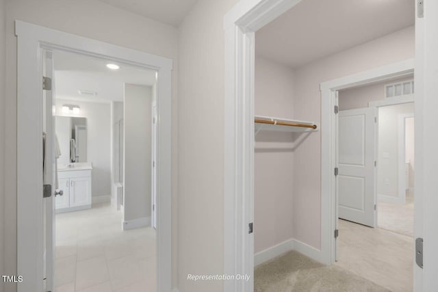 interior space featuring visible vents, light carpet, and baseboards