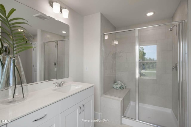 full bathroom with a stall shower, visible vents, and vanity