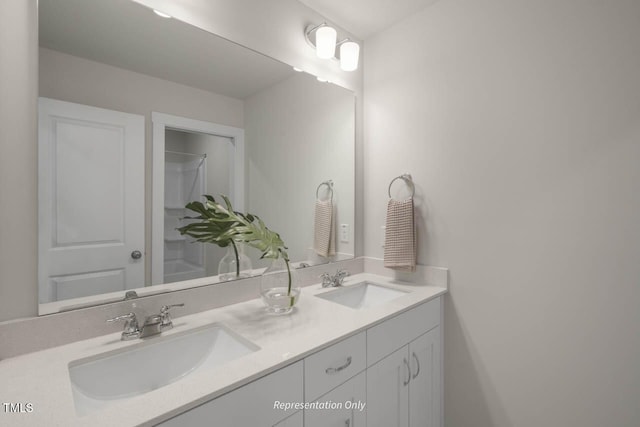 bathroom featuring double vanity, a shower, and a sink