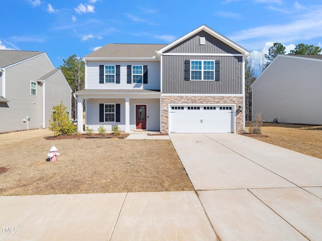 view of front of property with driveway, stone siding, a porch, board and batten siding, and an attached garage