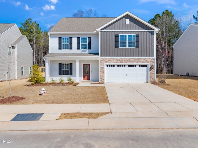 view of front of home with board and batten siding, concrete driveway, an attached garage, and stone siding