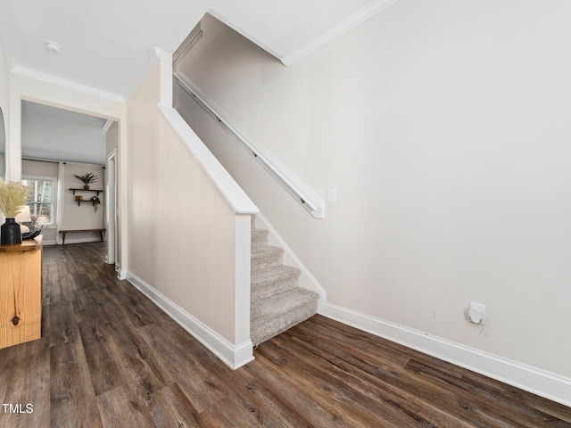 staircase with crown molding, baseboards, and wood finished floors