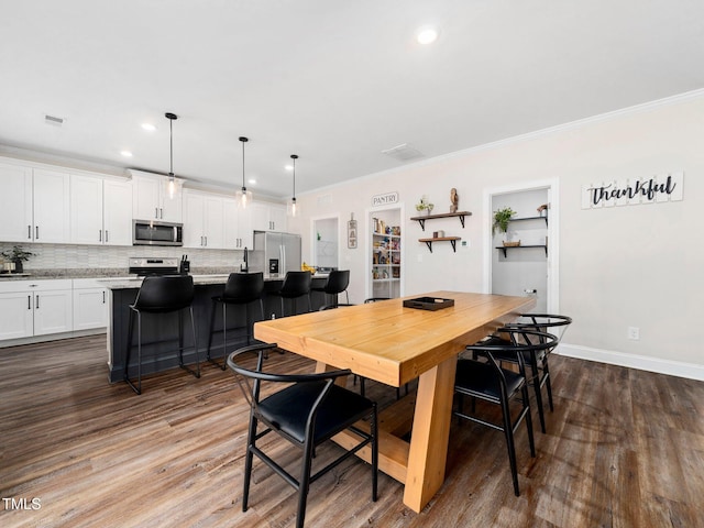 dining space featuring baseboards, visible vents, dark wood finished floors, recessed lighting, and ornamental molding