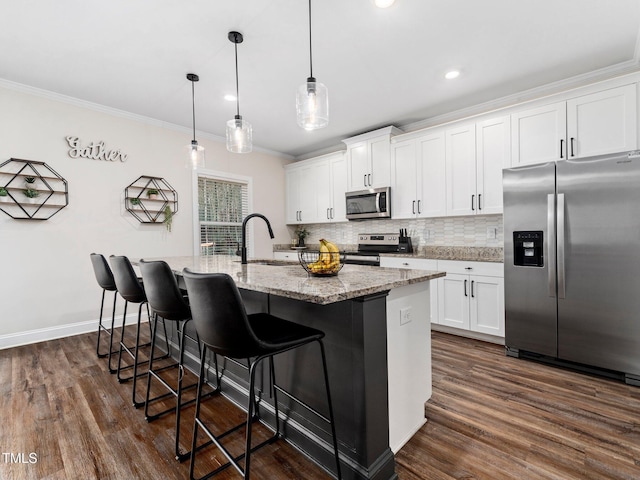 kitchen with a sink, stainless steel appliances, tasteful backsplash, and ornamental molding