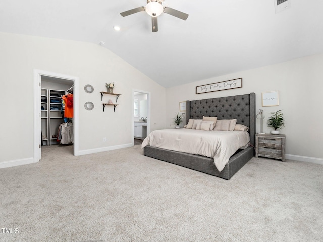 bedroom featuring a walk in closet, baseboards, carpet, and vaulted ceiling