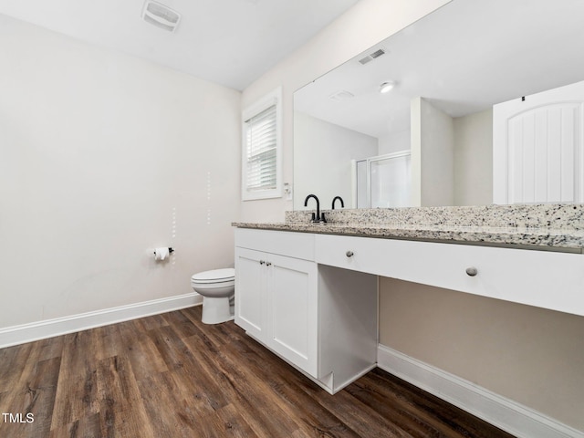 bathroom with visible vents, baseboards, wood finished floors, and a shower stall