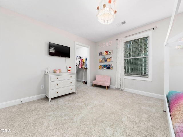 carpeted bedroom with visible vents, baseboards, a closet, and a walk in closet