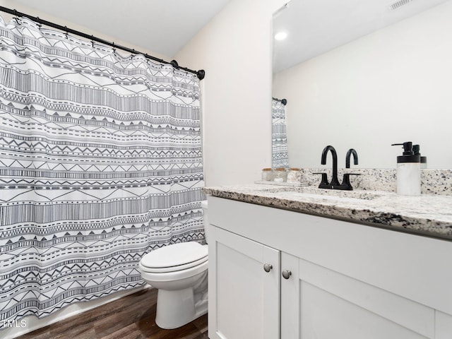 full bath with toilet, vanity, and wood finished floors