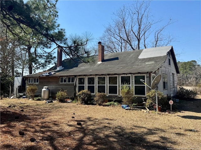 back of property with a chimney