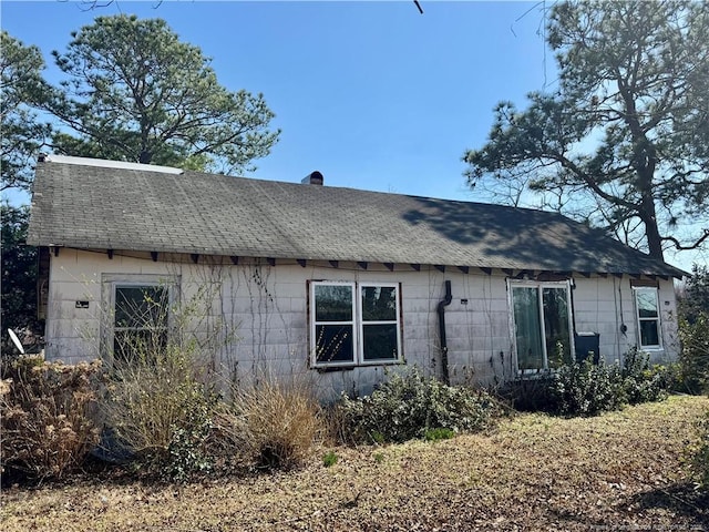 rear view of property with roof with shingles