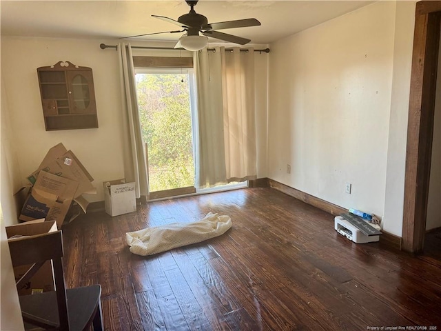 empty room featuring wood-type flooring, ceiling fan, and baseboards