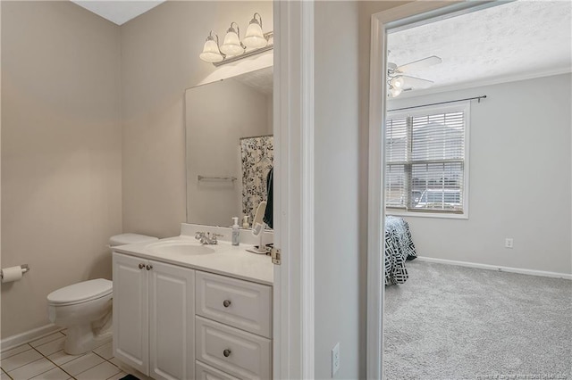 bathroom featuring tile patterned flooring, baseboards, vanity, and toilet