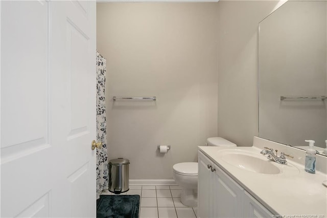 bathroom with toilet, vanity, baseboards, and tile patterned floors