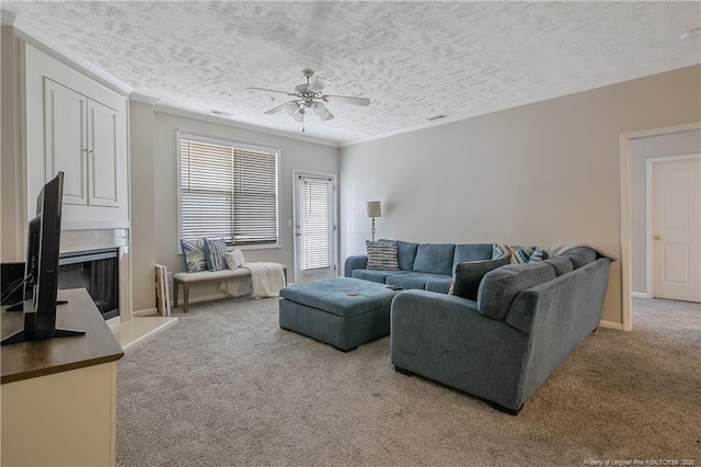 living area featuring carpet, ornamental molding, a fireplace with raised hearth, and a textured ceiling