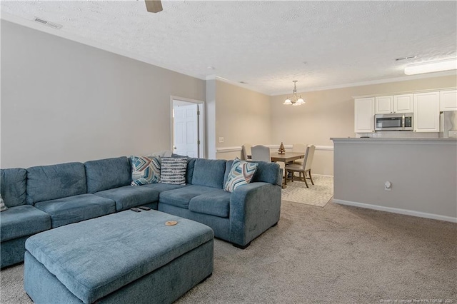 living room with a textured ceiling, light carpet, visible vents, baseboards, and crown molding