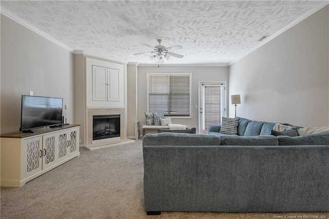 living area featuring carpet, a fireplace with raised hearth, crown molding, and visible vents