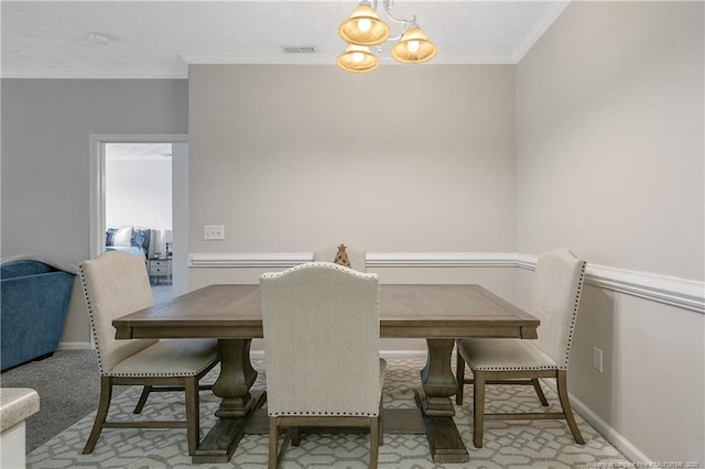 dining space with baseboards, visible vents, ornamental molding, and a notable chandelier