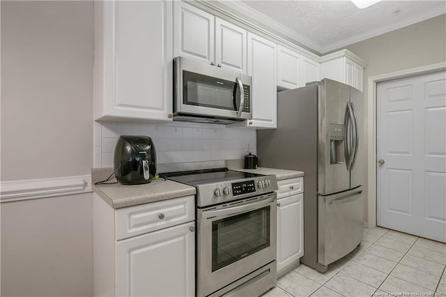 kitchen featuring light countertops, appliances with stainless steel finishes, backsplash, and white cabinetry