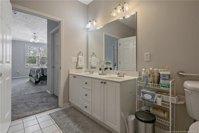 bathroom featuring double vanity, ensuite bath, a sink, and tile patterned floors