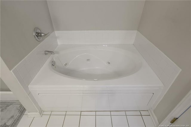 bathroom featuring tile patterned flooring and a tub with jets