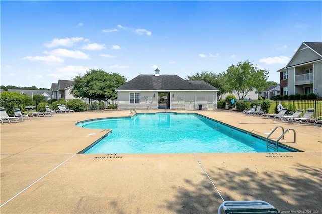 community pool featuring a patio area and fence