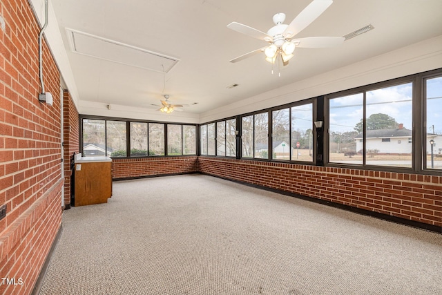 unfurnished sunroom featuring visible vents, plenty of natural light, and a ceiling fan