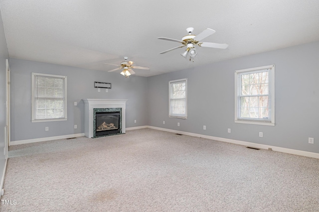 unfurnished living room featuring visible vents, light colored carpet, a fireplace, and baseboards