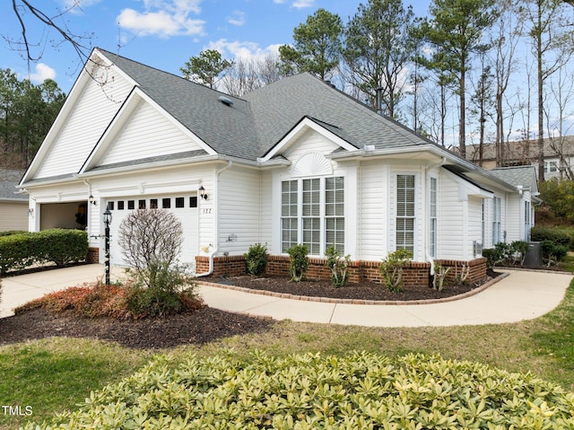 view of front of home with brick siding, driveway, a shingled roof, and an attached garage