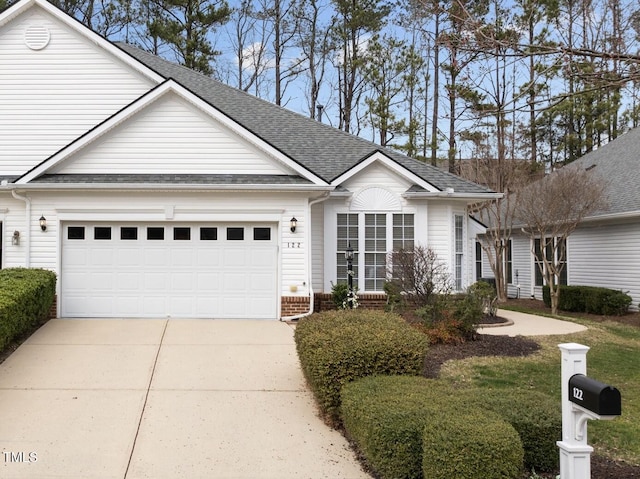 ranch-style house with a garage, brick siding, roof with shingles, and driveway