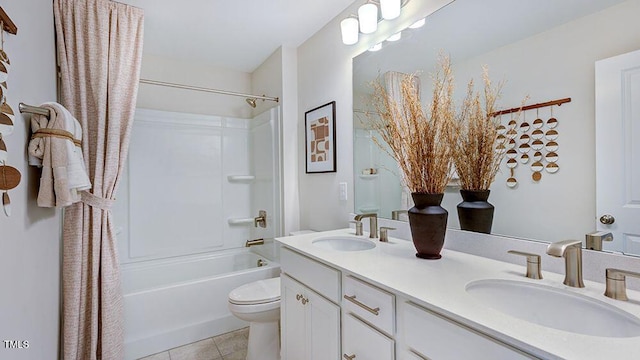 bathroom featuring double vanity, tile patterned flooring, a sink, and toilet