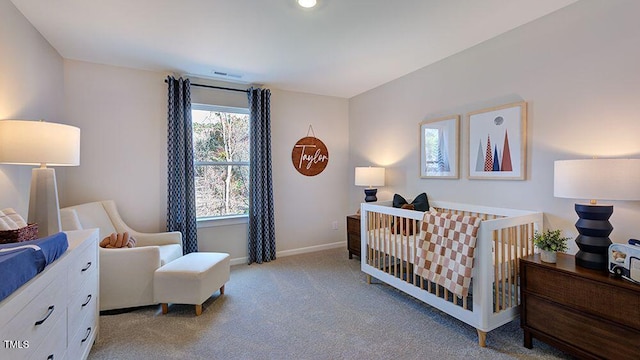 bedroom featuring a crib, visible vents, baseboards, and carpet flooring