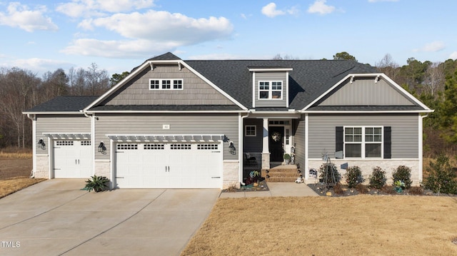 craftsman house featuring a garage, driveway, a shingled roof, and a front lawn