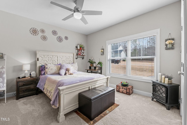 bedroom featuring a ceiling fan, light carpet, and baseboards