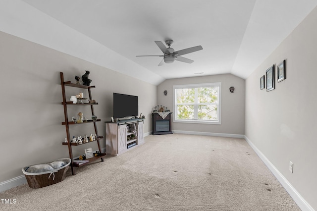 unfurnished living room featuring carpet flooring, vaulted ceiling, baseboards, and ceiling fan