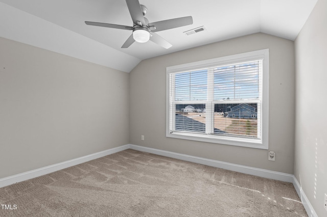 unfurnished room featuring lofted ceiling, baseboards, visible vents, and carpet flooring