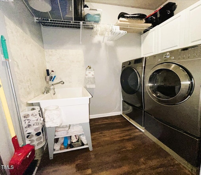 clothes washing area featuring dark wood-style flooring, independent washer and dryer, a sink, and cabinet space