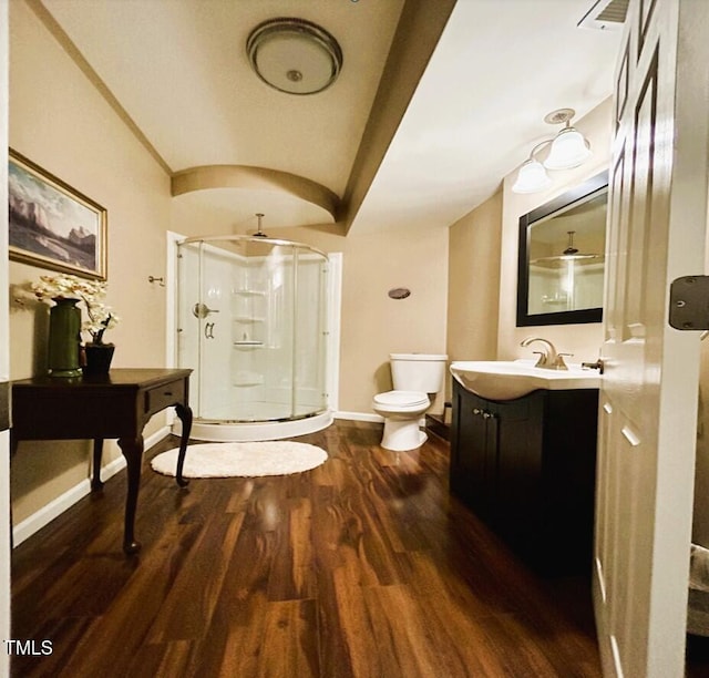 full bathroom featuring toilet, a stall shower, vanity, wood finished floors, and baseboards