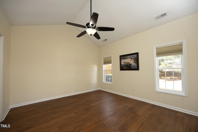 spare room featuring baseboards, visible vents, vaulted ceiling, and dark wood-style flooring