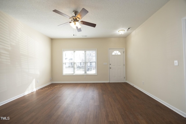 foyer entrance with visible vents, a textured ceiling, baseboards, and wood finished floors